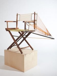 Designer repairs a chair with innovative structural components