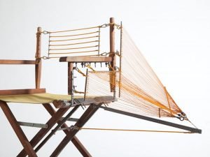 Designer repairs a chair with innovative structural components