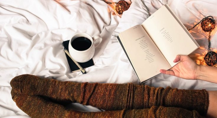 black coffee and journal on bed